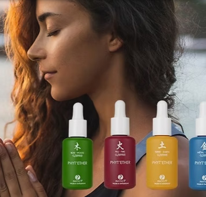 Vrouw met gesloten ogen, met op de voorgrond vier Phyto 5 flesjes in groen, rood, geel en blauw